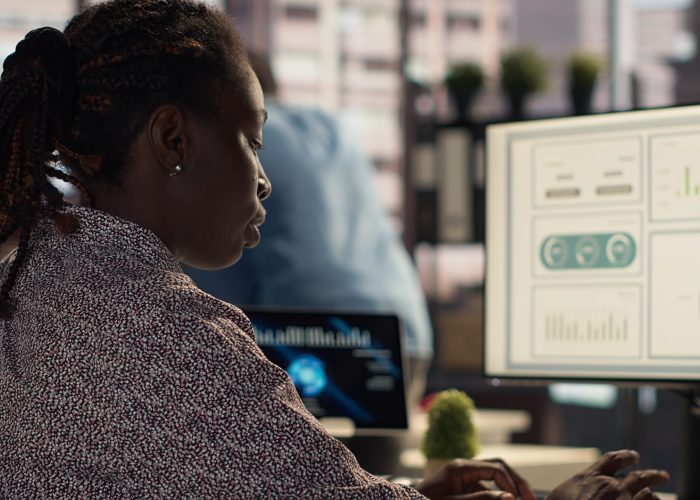 Female manager engaged in budget analysis and strategy development at her workstation, supporting objectives for company growth and collaboration. Strategizing business goals. Camera A.